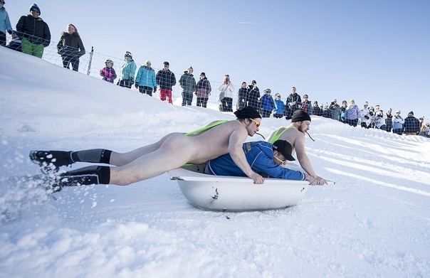 Ежегодный спуск в ванных на горнолыжном курорте в Швейцарии Трое или более человек в веселых костюмах должны максимально быстро спуститься с горки на ванной, что бы одержать победу в